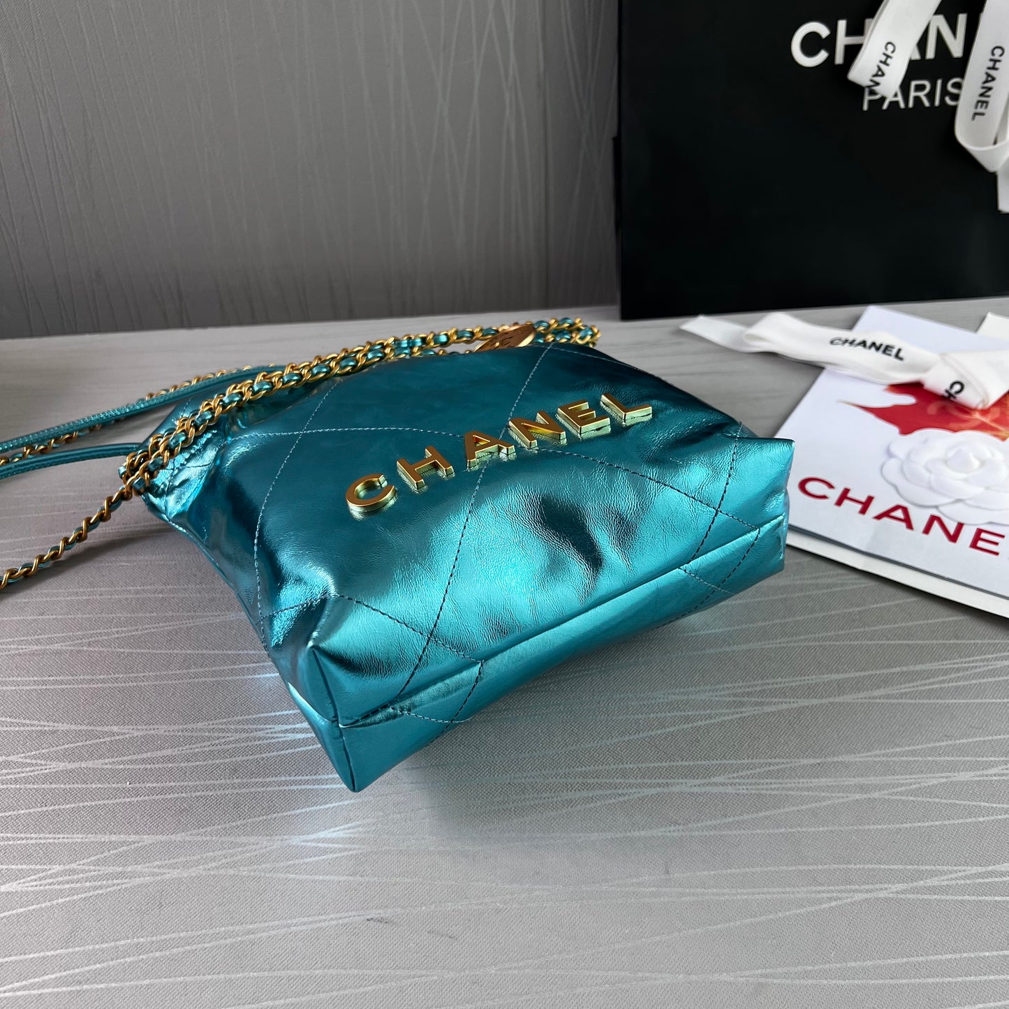 Bolso C piel metalizada color azul , tamaño mini y herrajes dorados