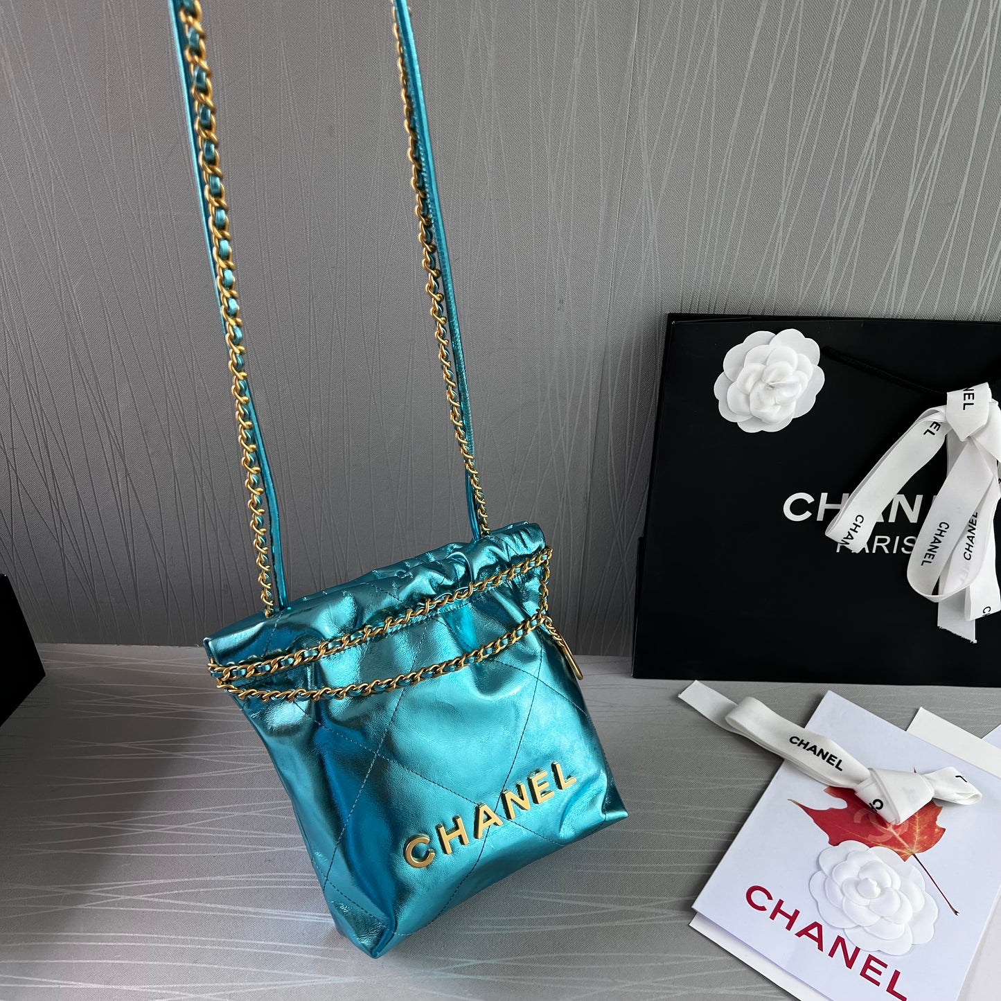Bolso C piel metalizada color azul , tamaño mini y herrajes dorados