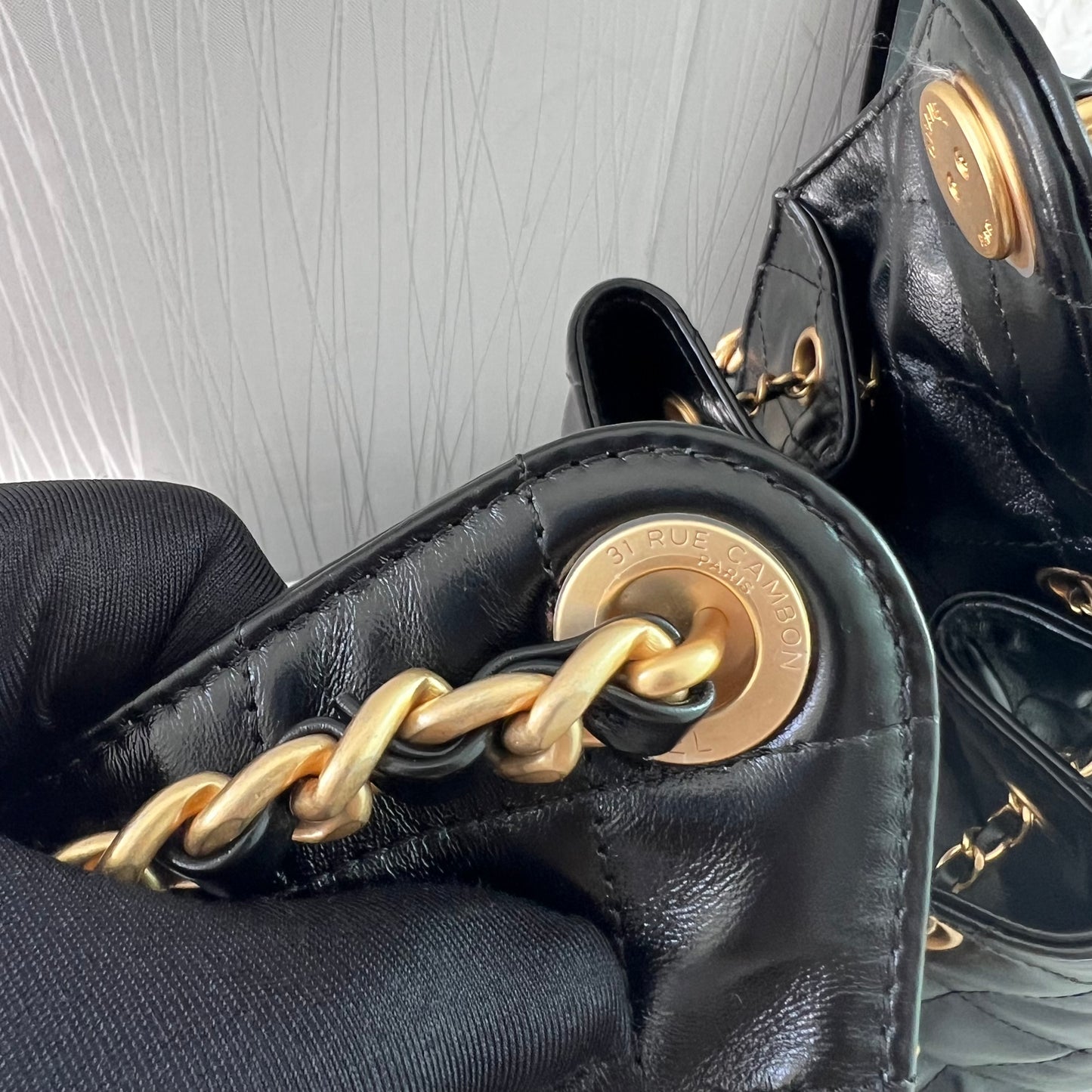 Bolso C piel negra con herrajes dorados