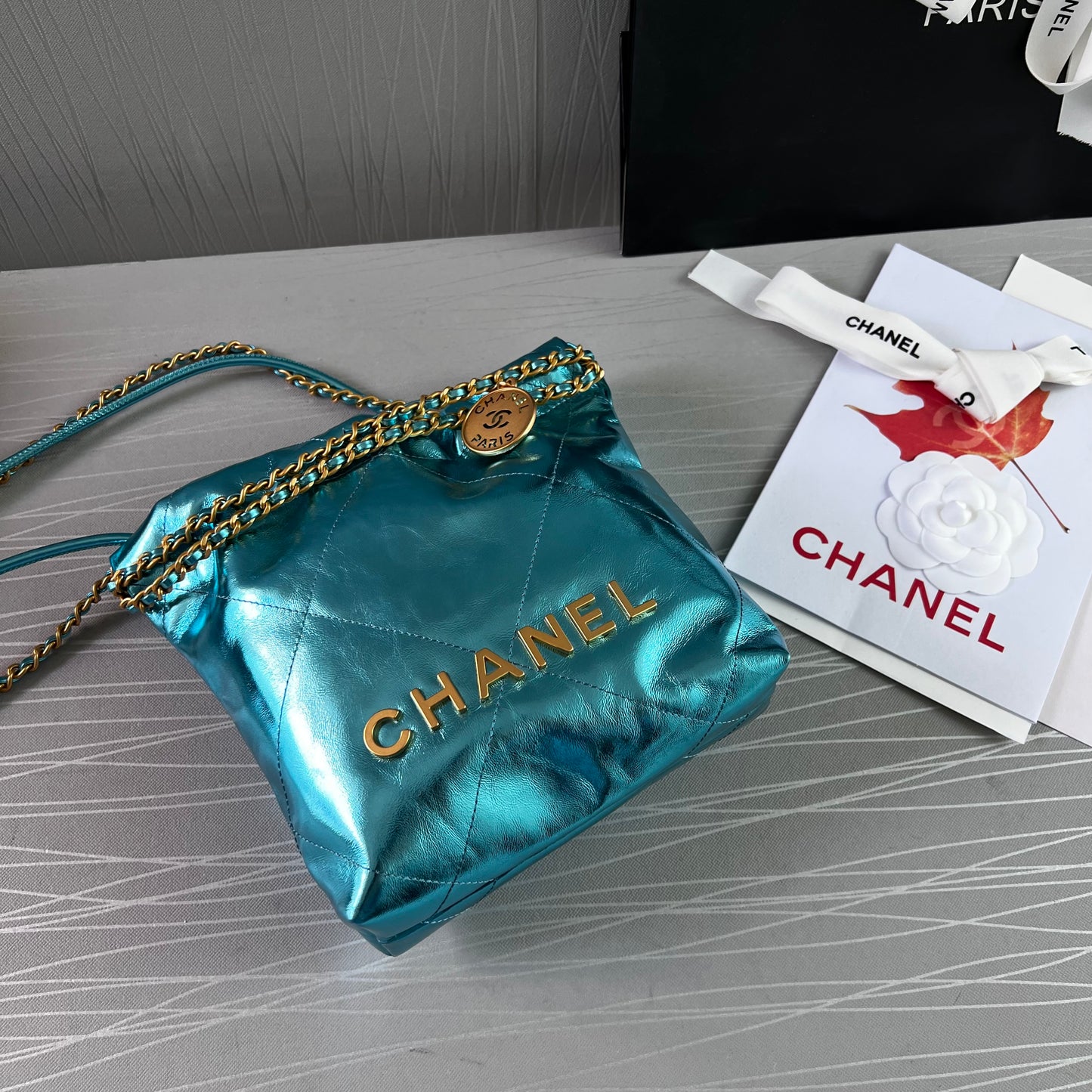 Bolso C piel metalizada color azul , tamaño mini y herrajes dorados